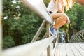 Young woman sitting on a bridge railing in jeans sneakers Royalty Free Stock Photo