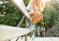 Young woman sitting on a bridge railing in jeans sneakers Royalty Free Stock Photo