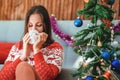 Young woman is sitting in a cafe and drink with a snowman cup. Christmas concept