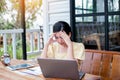 Young woman sitting in a cafe with her laptop, Stressful for work Royalty Free Stock Photo