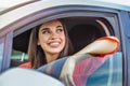Young woman sitting in a car. Happy woman driving a car and smiling. Portrait of happy female driver steering car with safety belt Royalty Free Stock Photo