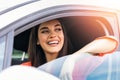 Young woman sitting in a car. Happy woman driving a car and smiling. Portrait of happy female driver steering car with safety belt Royalty Free Stock Photo