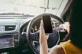 Young woman sitting in car and using her smartphone. safety and communication concept. Royalty Free Stock Photo