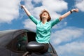 Young woman sitting on a car window and holding a key Royalty Free Stock Photo