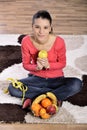 Young woman sitting on carpet and enjoying fruits