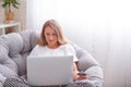 Young woman is sitting in a chair with a laptop and making purchases online Royalty Free Stock Photo