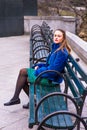 Young Woman sitting on chair outdoors in winter, relaxing, waiting Royalty Free Stock Photo