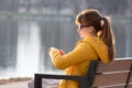 Young woman sitting on city street alone waiting for someone to arrive. Being late on date meeting concept