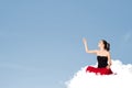 Young woman sitting on cloud with copy space Royalty Free Stock Photo