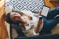 Young woman sitting on a couch and doing online shopping using her tablet. Social distancing caused quarantine Royalty Free Stock Photo