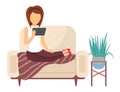 Young woman sitting on the couch with a tablet. The girl with electronic equipment watching video