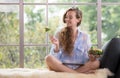 Young woman sitting on a couch using tablet and holding a salad bowl Royalty Free Stock Photo