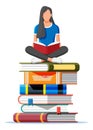 Woman sitting cross-legged on stack of books