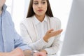 Young woman sitting at the desk with computer in white colored office. Looks like student girl or business lady Royalty Free Stock Photo