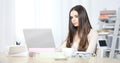 Young woman sitting at desk in office room and working on her laptop Royalty Free Stock Photo
