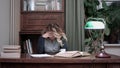Young woman sitting at desk tired of working and taking her head in hands Royalty Free Stock Photo