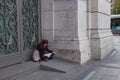 Woman sitting in the doorway of the Bank of Spain