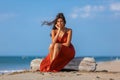 YOUNG WOMAN SITTING ON THE SAND OF THE BEACH Royalty Free Stock Photo