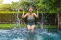 Woman sitting on edge of swimming pool and playing water splashing Royalty Free Stock Photo