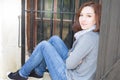 Young woman sitting on the edge of the window of the house Royalty Free Stock Photo