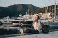 Young woman sitting on Embankment on the beach at sunset and prints in the laptop. Vacations, freelancer, lifestyle, Successful c