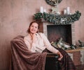 Young woman sitting by the fireplace in a cozy living room Royalty Free Stock Photo