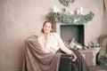 Young woman sitting by the fireplace in a cozy living room Royalty Free Stock Photo