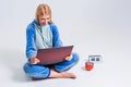 Young woman sitting on the floor in his pajamas with a laptop. Royalty Free Stock Photo