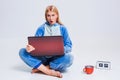 Young woman sitting on the floor in his pajamas with a laptop. Royalty Free Stock Photo