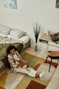 Young woman sitting on floor at home and cuddling with little pet dog Royalty Free Stock Photo