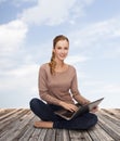 Young woman sitting on floor with laptop