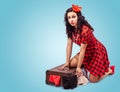 Young woman sitting on the floor and putting clothes in a suitcase Royalty Free Stock Photo