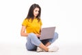 Young woman sitting on the floor and using laptop on white background Royalty Free Stock Photo