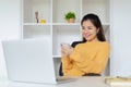 Young woman sitting in front of computer laptop and using mobile phone Royalty Free Stock Photo