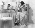 Young woman sitting in front of her vanity doing her hair Royalty Free Stock Photo