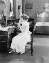 Young woman sitting in front of her vanity table and grooming her hair Royalty Free Stock Photo