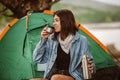 Woman sitting in front of the tent drinking tea Royalty Free Stock Photo