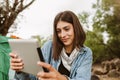 Woman sitting in front of the tent using digital tablet Royalty Free Stock Photo