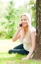 Young woman sitting on grass with phone Royalty Free Stock Photo