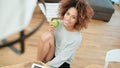 Young woman sitting with green apple at home and smiling at camera. Royalty Free Stock Photo