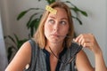 A young woman sitting at her Desk, holding glasses near mouth and thinking about something. On the forehead sticker with question Royalty Free Stock Photo