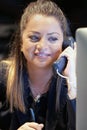 Young woman sitting at her desk working and answering a phone call. Royalty Free Stock Photo