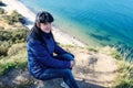 Young woman sitting on a high seashore