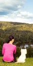 Young woman sitting on the hill with white dog Royalty Free Stock Photo