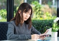 Young woman sitting holding passport and credit card Royalty Free Stock Photo