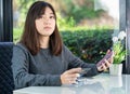 Young woman sitting holding passport and credit card Royalty Free Stock Photo