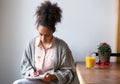 Young woman sitting at home writing on note pad Royalty Free Stock Photo