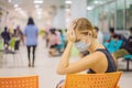 Young woman sitting in hospital waiting for a doctor`s appointment. Patients In Doctors Waiting Room