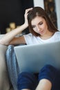 Young woman sitting with laptop on sofa at her home Royalty Free Stock Photo