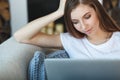 Young woman sitting with laptop on sofa at her home Royalty Free Stock Photo